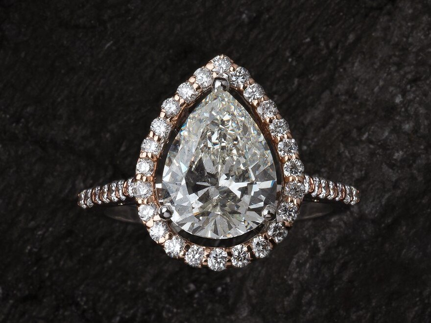 A pear-cut diamond engagement ring in a rose gold halo setting