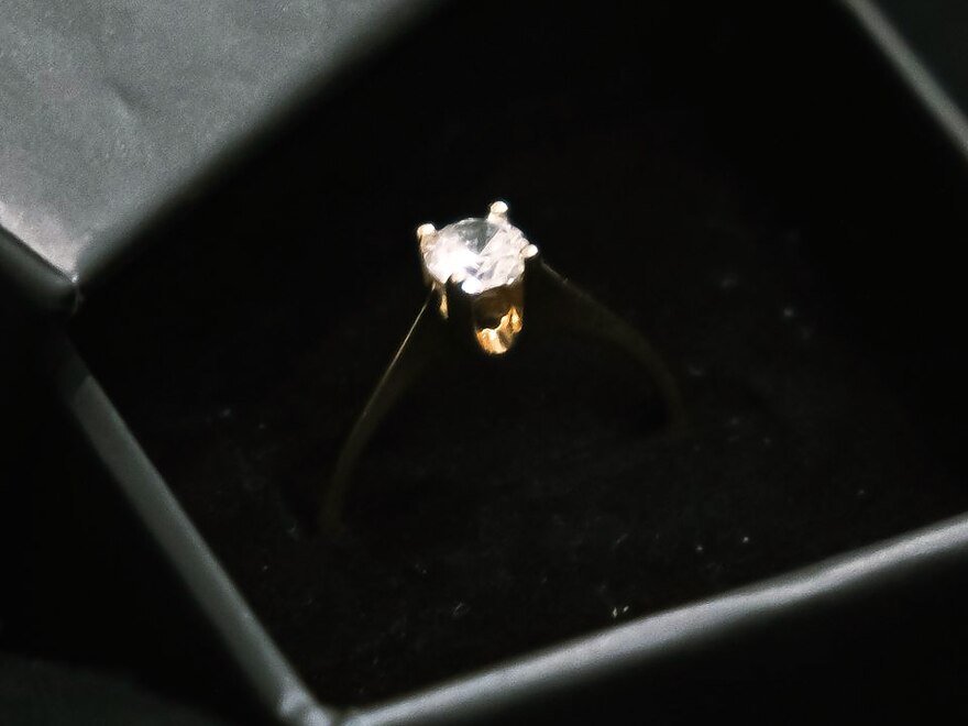 A gold ring presented in an open gift box