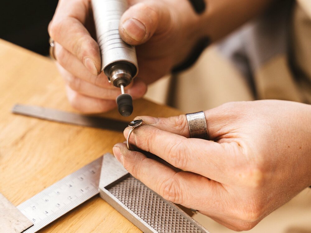 A finished ring being polished by hand