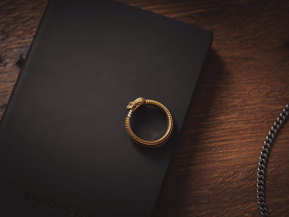 A gold ring resting on a dark surface
