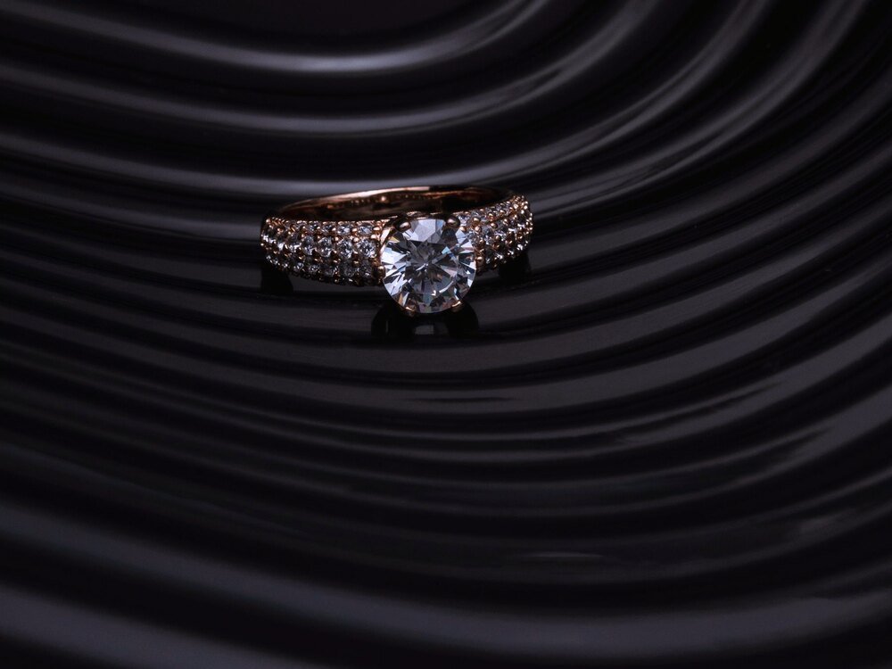A diamond ring on dark pleated fabric